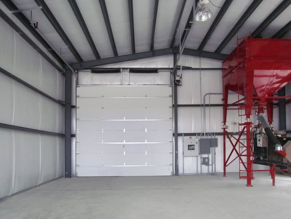 Technician Installing Heavy-Duty Steel Garage Door Commercial Warehouse