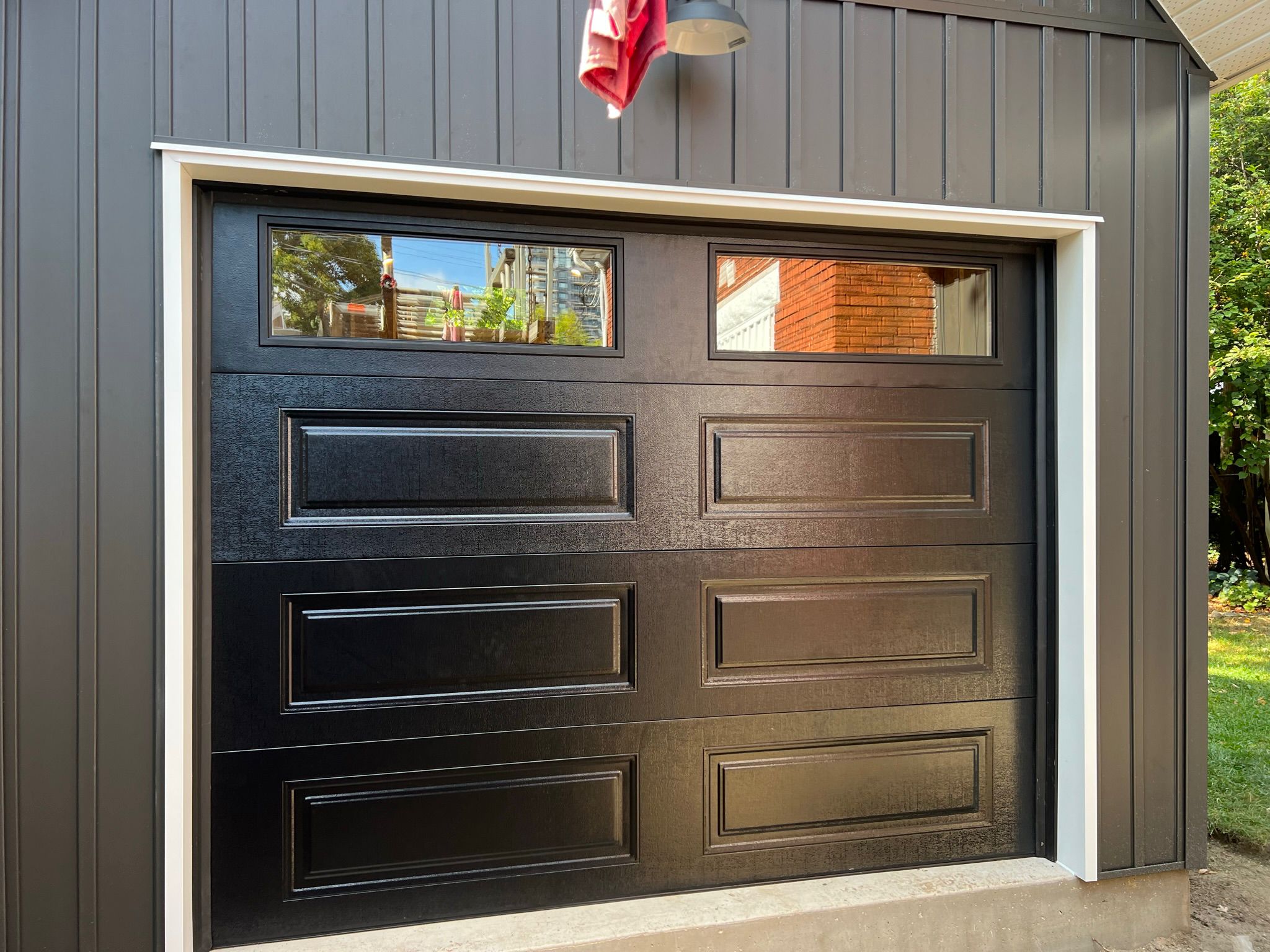 Display featuring various wood samples used in crafting black garage doors