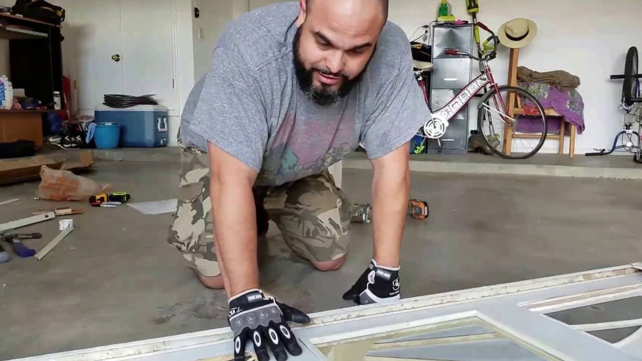 Person measuring garage door opening with tape measure for panel installation